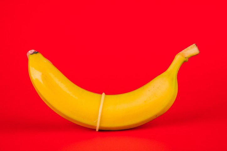 Bondara Sex Toy Blog - Quick Talk About Sexual Health - Banana with Condom on Red Background
