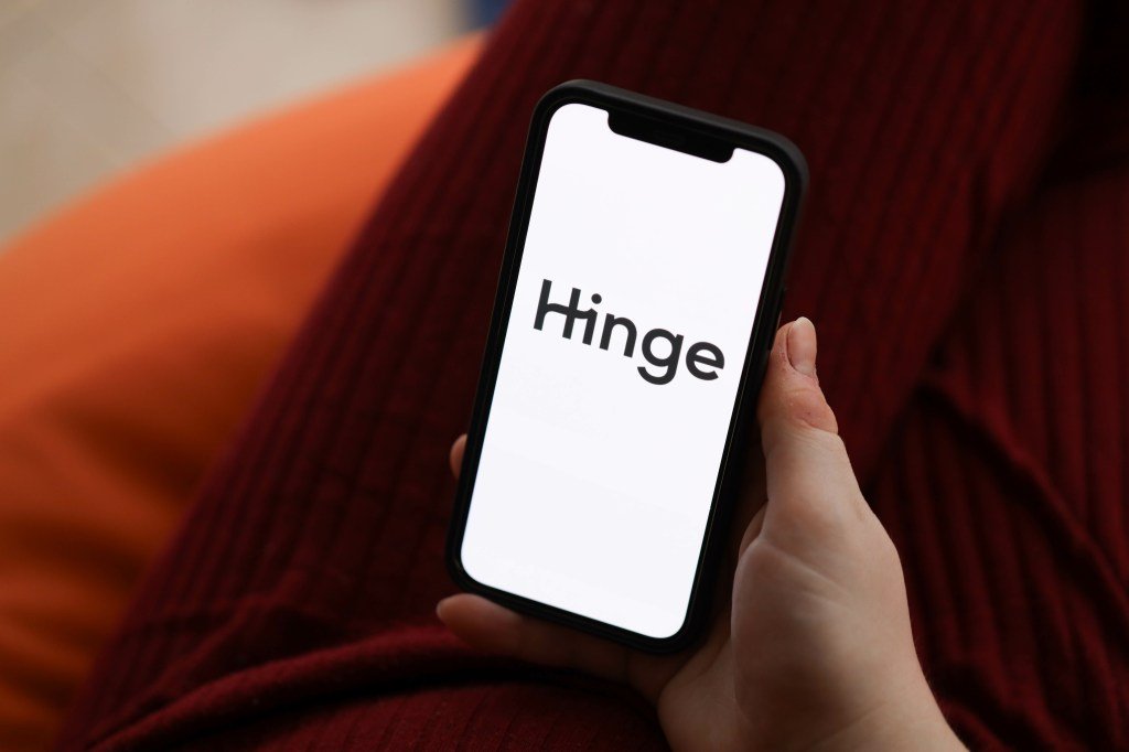 Close-up of handheld iPhone display showing Hinge dating app logo against background in Kiev, Ukraine February 23, 2024.