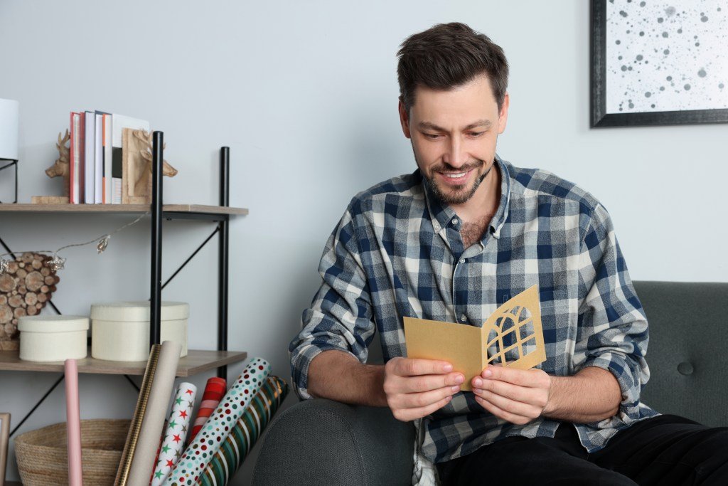 Happy man reading greeting card.