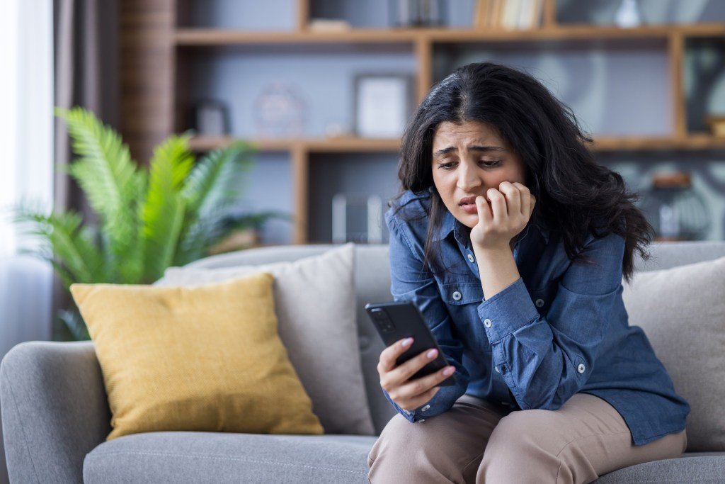 Worried woman looking at her phone.