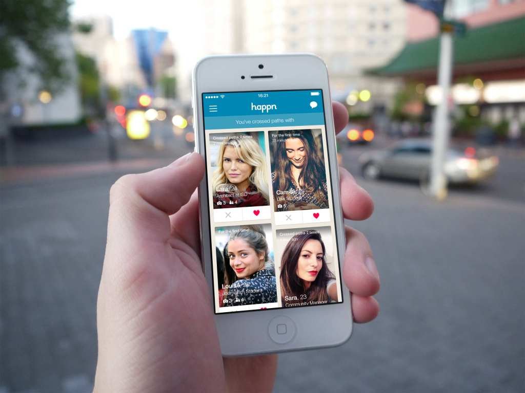 Smartphone displays Happn dating app.