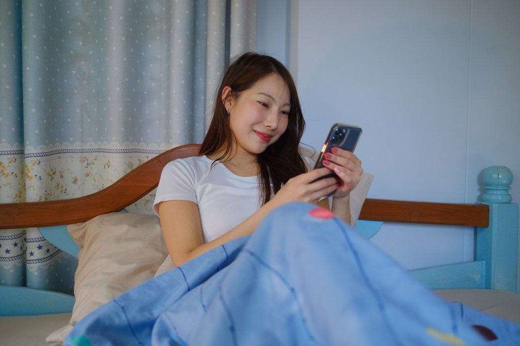 Woman lying on the bed talking on the phone.